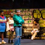 'Is This Good Enough' by Avaes Mohammad, performed by Eastbury Drama Group. Four young people dress colourful in front of a graffiti wall set.