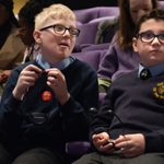 Young person testing their hearing loop before the performance of The Witches after the schools touch tour