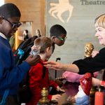 Young person holding a prop mouse during The Witches schools touch tour