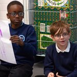 Two young people showing their drawing of a Witch during The Witches schools workshop