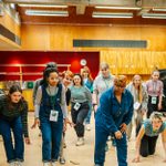 A group of people physically moving in a workshop space