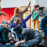 A group of people creating a physical sculpture in a workshop space