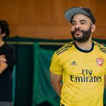 Ashley Gerlach, wearing a yellow Arsenal football shirt and baseball cap, and another cast member rehearsing Hamlet for younger audiences