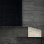 A black and grey image of a concrete tower, terraces and other structures of the National Theatre.