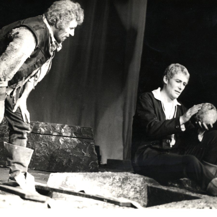 Actor Frank Finlay as Gravedigger and Peter O'Toole as Hamlet, holding a skull, on stage at the National Theatre, 1963