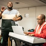 Kyle Ramar Freeman standing and singing, and Michael R. Jackson playing eletric keyboard, in rehearsals for A Strange Loop.