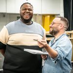 Kyle Ramar Freeman and Stephen Brackett standing together, sharing a joke, in rehearsals for A Strange Loop.