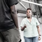 Michele Austin performing a scene in the rehearsal room. She is wearing a green striped top.