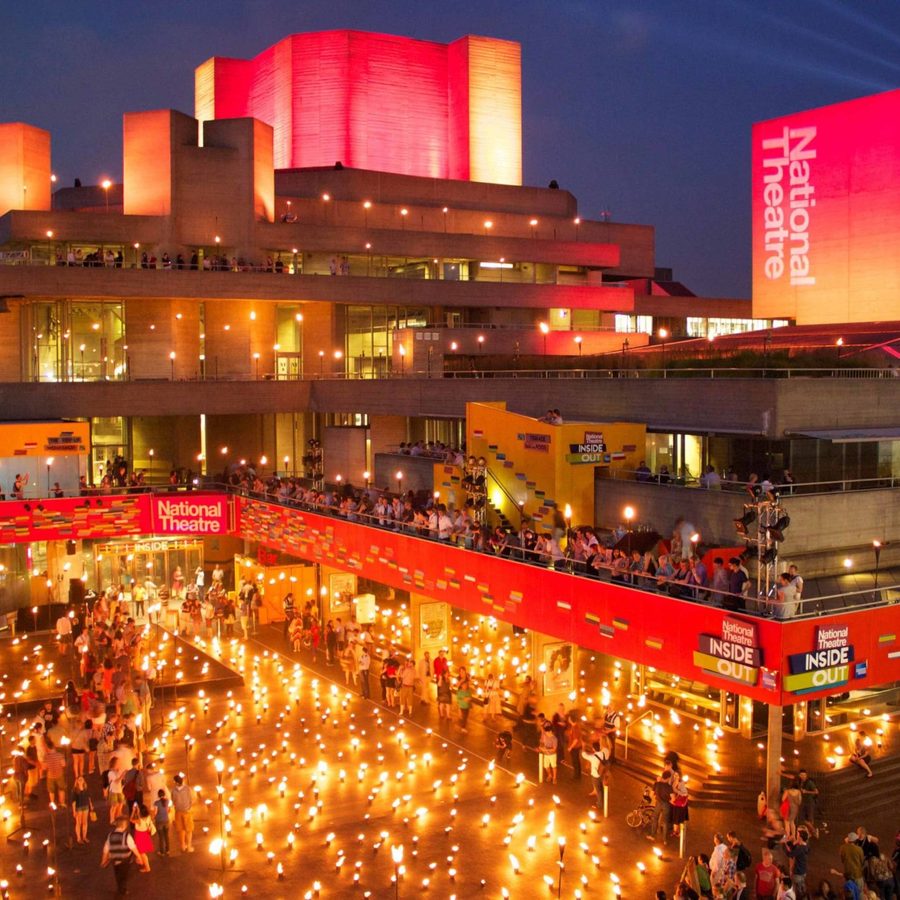 National Theatre bulding festooned with small flaming beacons filling Theatre Square, with crowds on the terraces.