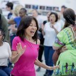 Focus on an individual in rehearsal, smiling.