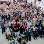 A bird's eye image of the As You Like It company in rehearsal, smiling and waving.