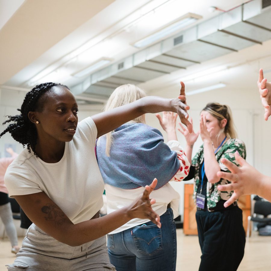 Two teachers moving their hand in the air for a workshop during Drama Teacher Conference 2023