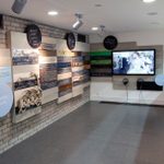 A shot of the Sherling High Level walkway backstage at the National Theatre, a balcony overlooking the set and prop-making departments, and with wall texts and video screen.