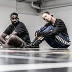 Taylor Russell and Paapa Essiedu sitting in the rehearsal room. Paapa is looking at Taylor and Taylor is looking off into the distance.