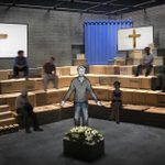 A model box design featuring wooden boxes as raked seating with wooden crosses on the wall